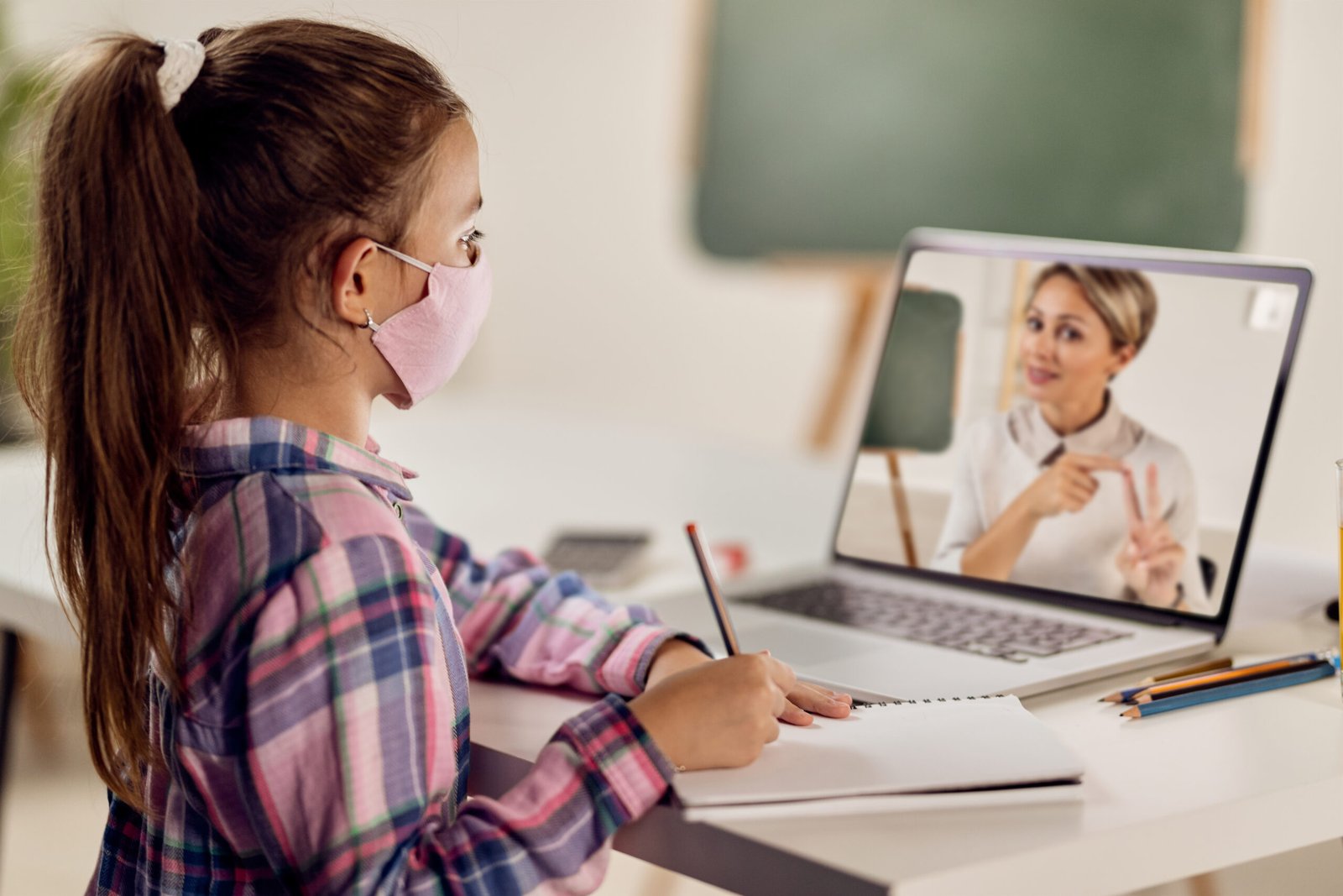 Student attending an online class with her teacher